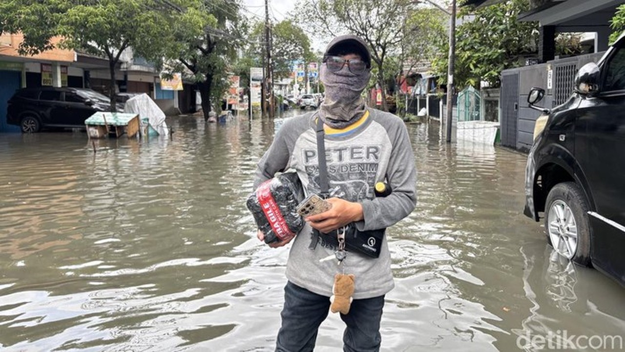 Cerita Candra, Kurir Bekasi Terjang Banjir Demi Antar Paket Warga